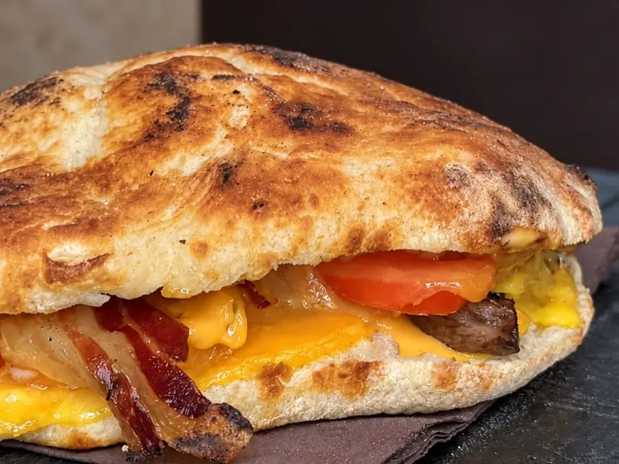 Un panino pizza di Bardy's con bacon, formaggio fuso e pomodoro